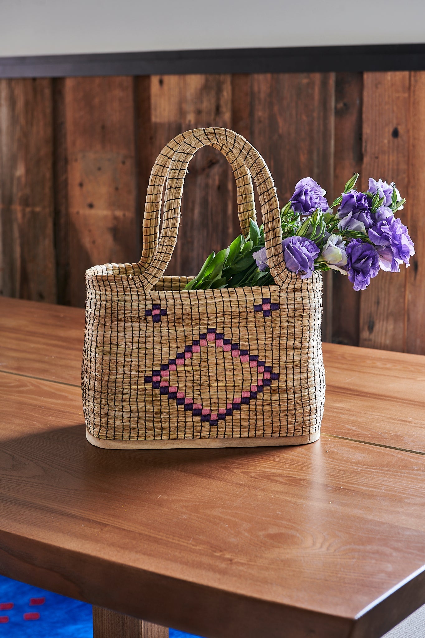 Handmade basket tote bag in Argentina of natural Palma and solid Lenga wood base with thread embroidery. Uniquely display blankets for home décor, market tote bag, accessories.