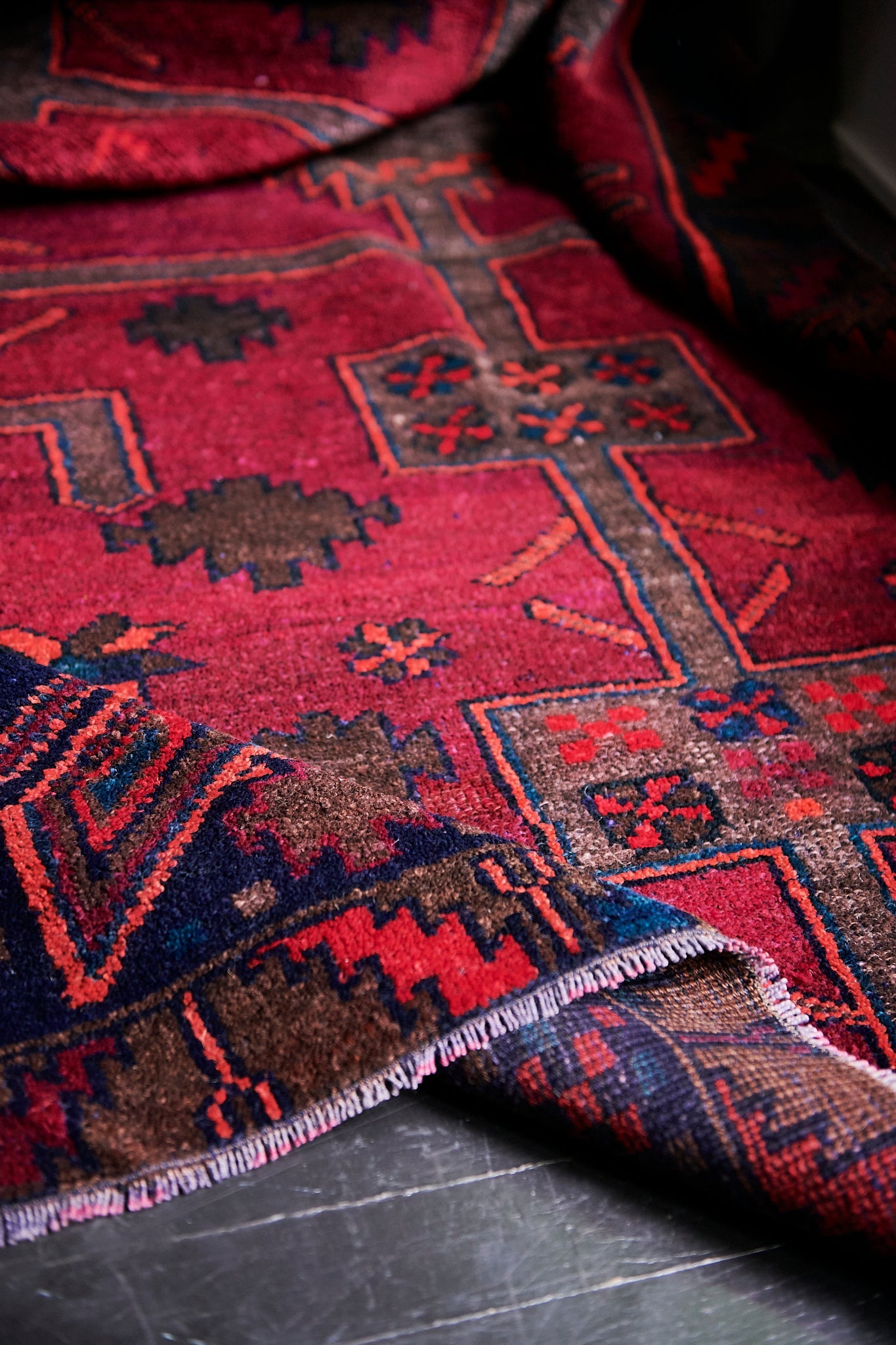 Antique Persian rug is one-of-a-kind and hand-knotted out of all-natural wool and cotton. Loomed in a traditional Persian rug style, this rug is a vintage find sourced from Iran. Full of bright and vibrant magenta, olive, navy and coral colors for your living room, under dining table, or anywhere else for unique, ethnic home decor. Floor rug, area rug