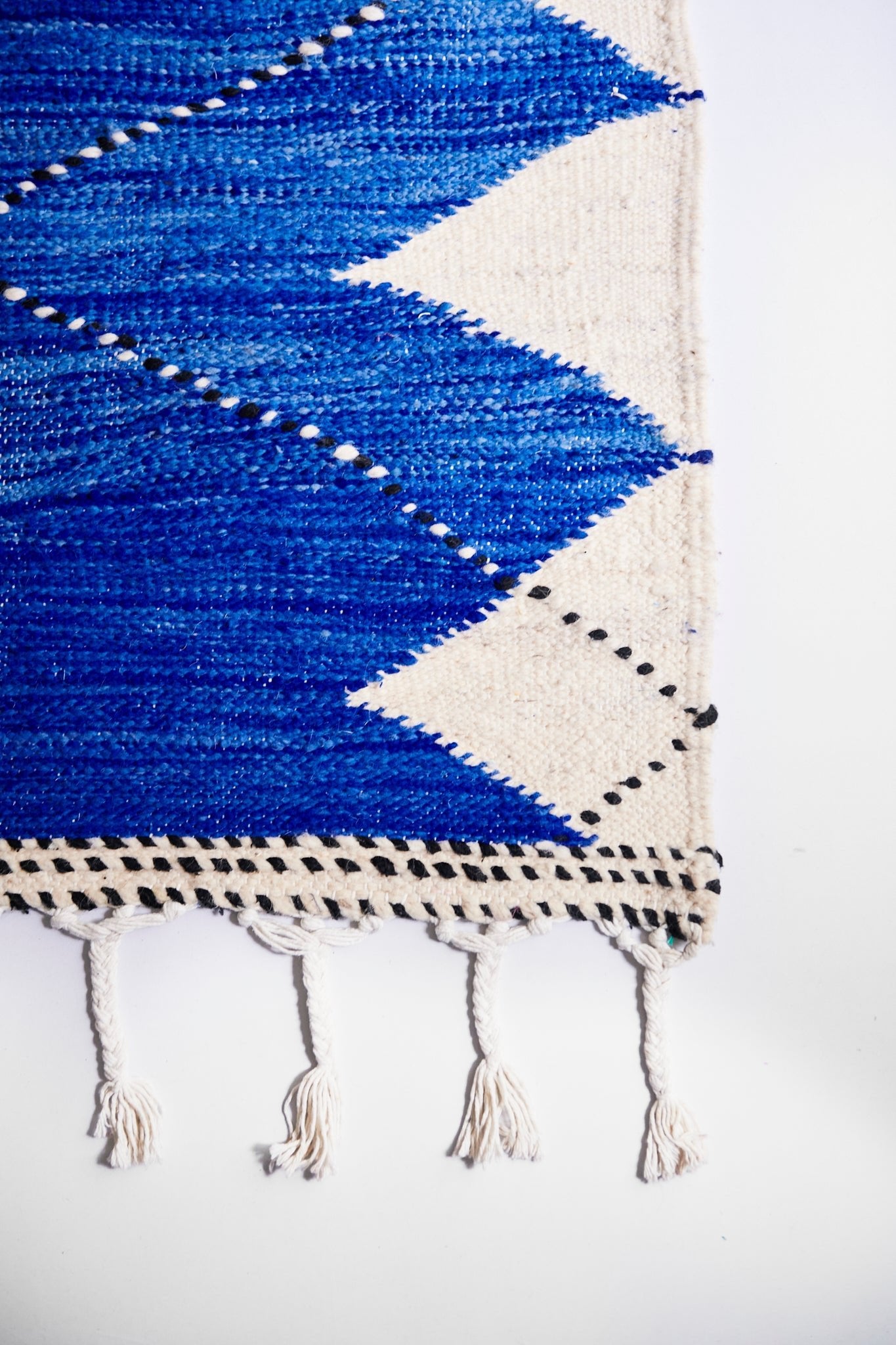 Oversized Moroccan Berber rug is uniquely and sustainably handmade by women artisans near Fes, Morocco out of a wool and cotton blend. Blue, Cream and Black Geometric X design is an authentic Moroccan style made in colorful, bright and vibrant colors for your living room, under dining table, or anywhere else for unique, ethnic home decor. Area floor rug